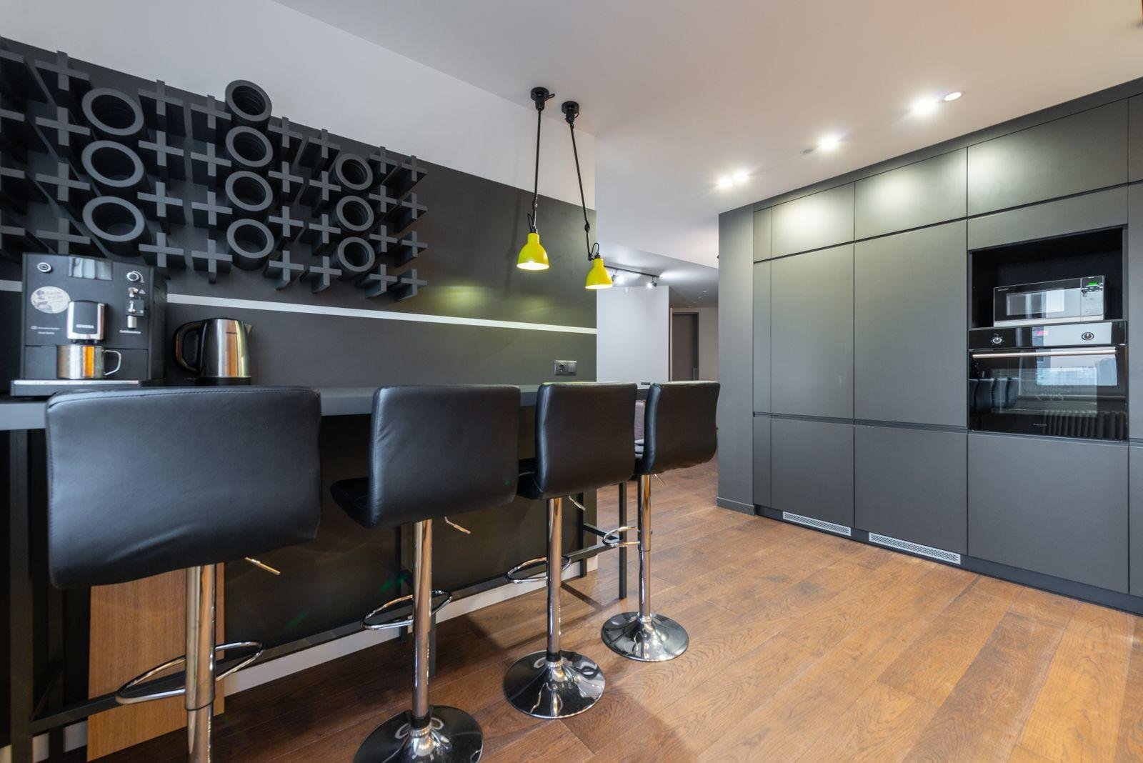 Black upholstered bar stools at a kitchen island – what it costs to reupholster a bar stool in New Zealand