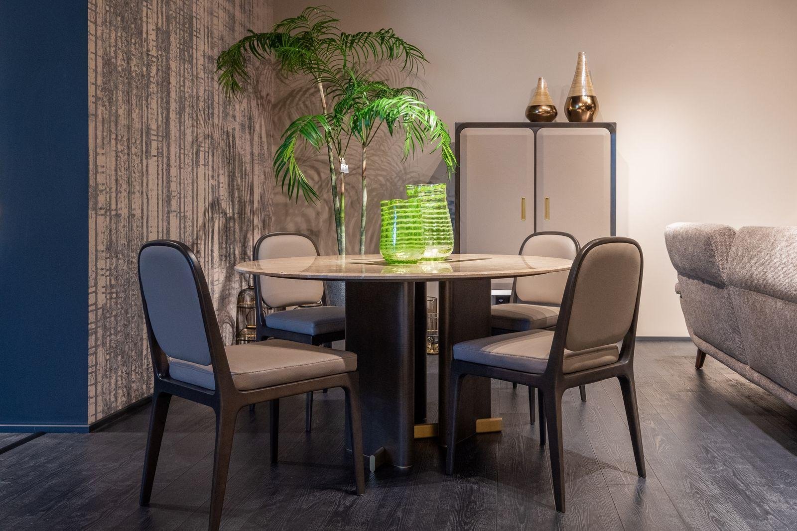 Upholstered dining chairs around a round table in a modern dining room – the benefits of professional upholstery services in Auckland