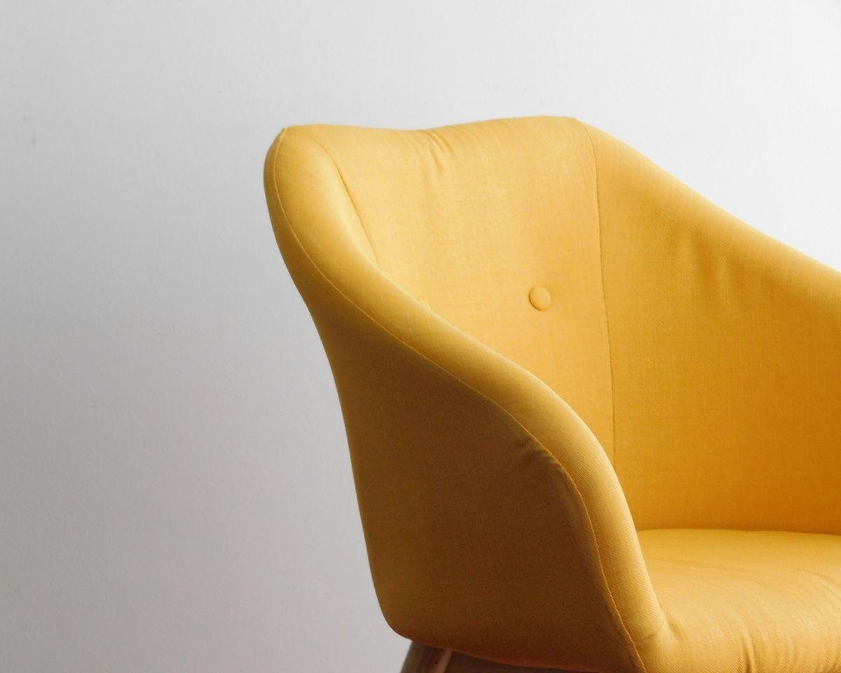 Upholstered armchair against a plain wall, illustrating armchair reupholstery costs in Auckland