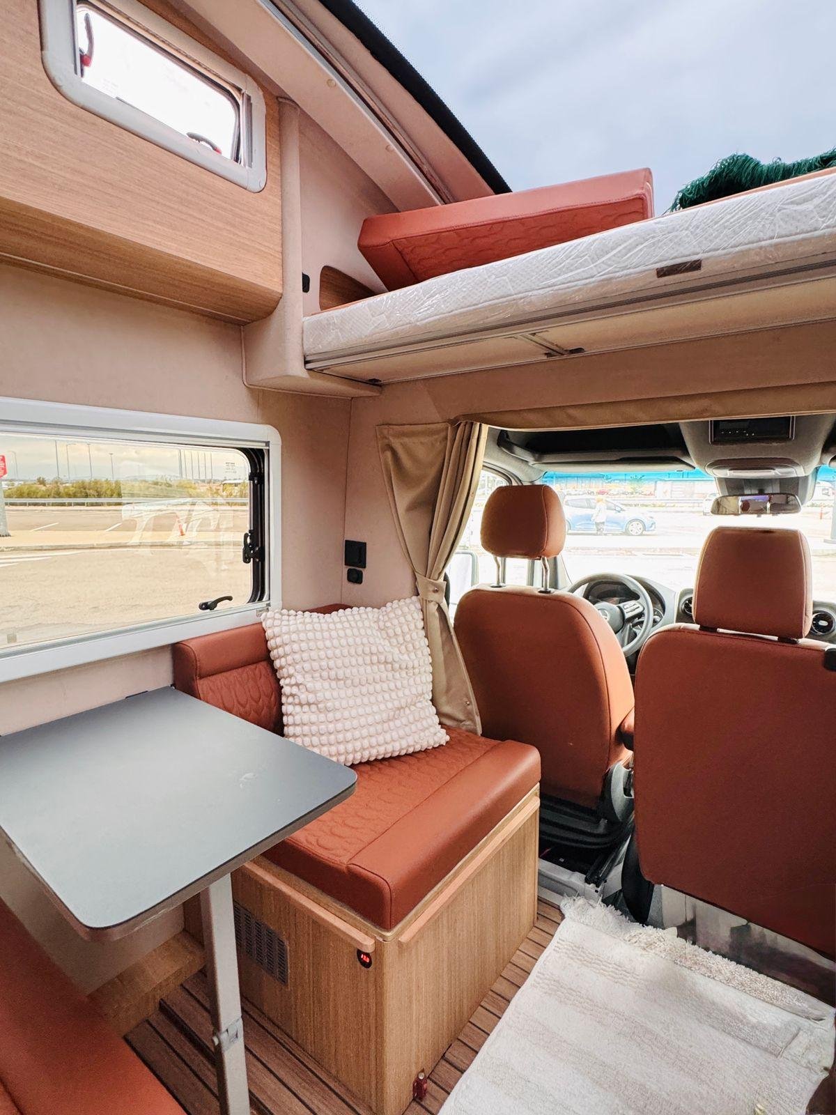 Modern campervan interior with upholstered seating and cushions