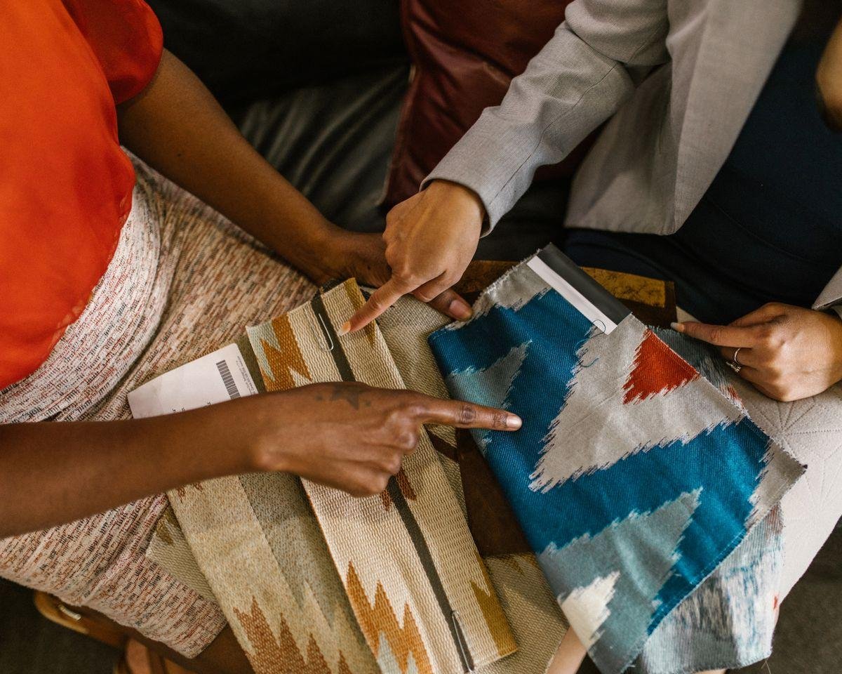 Two people comparing colourful upholstery fabric swatches when choosing fabric