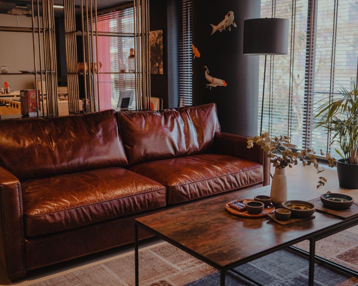 Brown leather sofa in a modern living room, comparing leather and fabric upholstery options