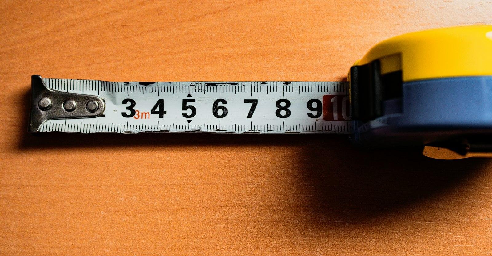 Yellow tape measure extended across a wooden surface